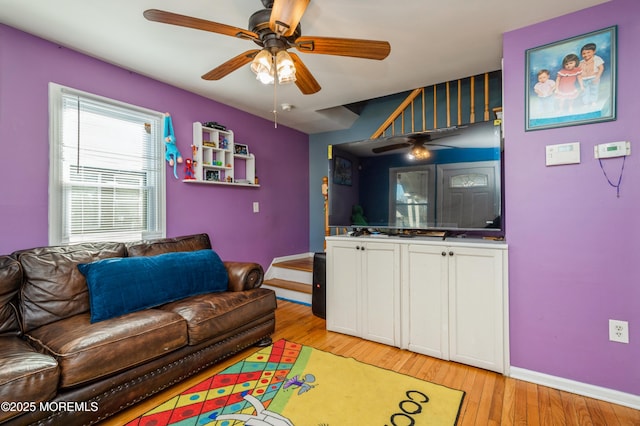 living room with ceiling fan and light hardwood / wood-style flooring