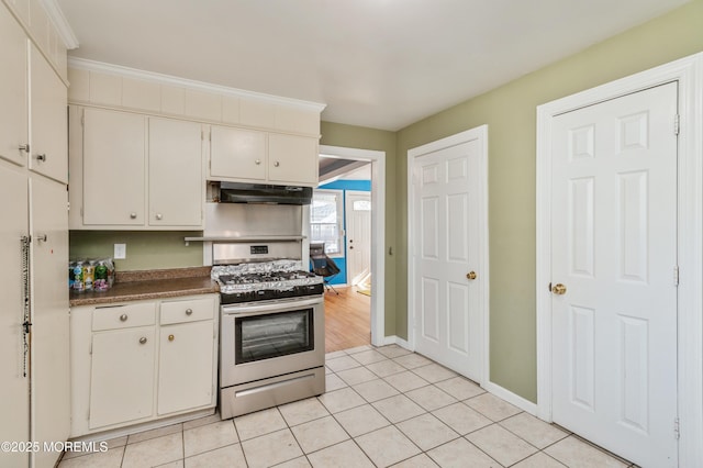 kitchen with gas range, white cabinetry, and light tile patterned floors