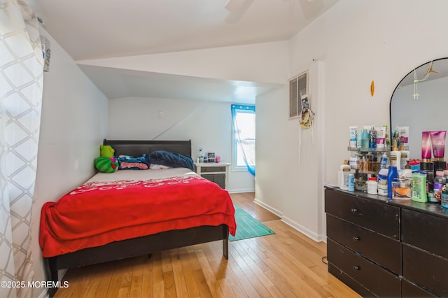 bedroom with lofted ceiling and light hardwood / wood-style floors