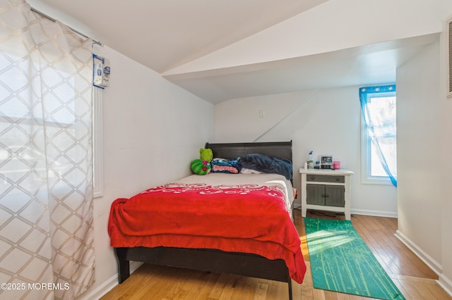 bedroom with lofted ceiling and wood-type flooring