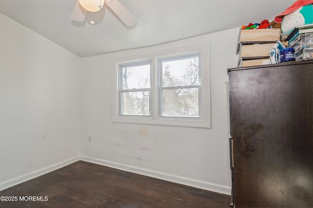 empty room with dark wood-type flooring and ceiling fan