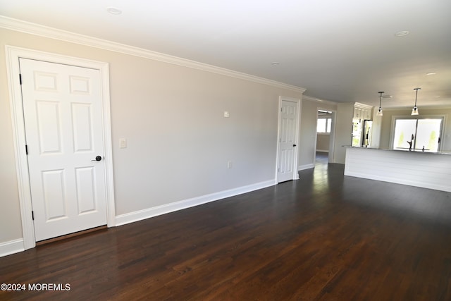 unfurnished living room featuring dark wood-type flooring and crown molding