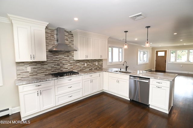 kitchen featuring appliances with stainless steel finishes, decorative light fixtures, sink, kitchen peninsula, and wall chimney exhaust hood