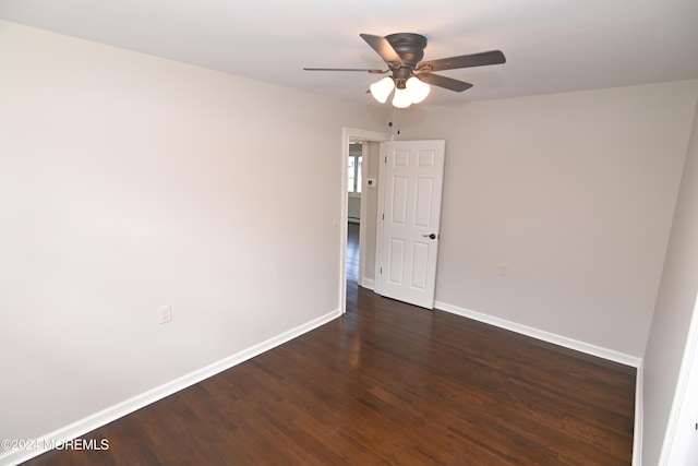 empty room with dark wood-type flooring and ceiling fan