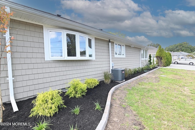 view of home's exterior featuring central AC unit and a lawn