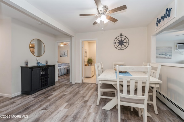 dining area with a wall mounted air conditioner, light hardwood / wood-style floors, ceiling fan, and baseboard heating