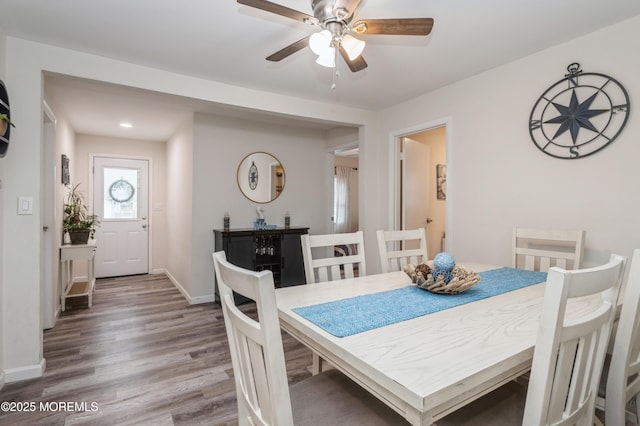 dining space featuring wood-type flooring and ceiling fan