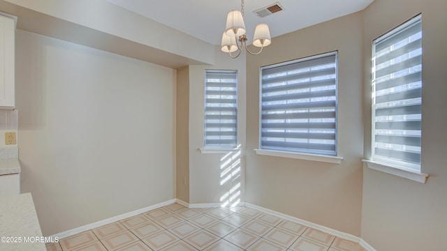 unfurnished room featuring an inviting chandelier and plenty of natural light