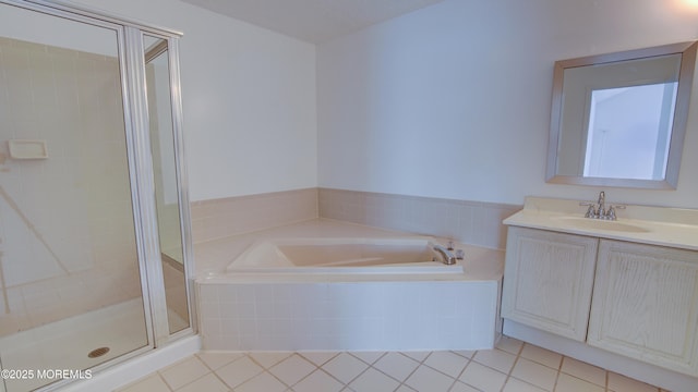 bathroom with tile patterned flooring, vanity, and walk in shower