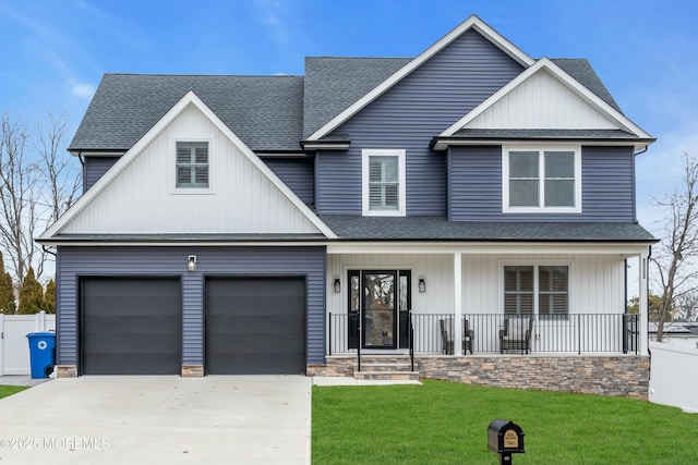 view of front of property featuring a garage, a front lawn, and a porch