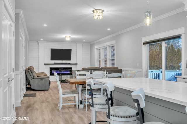 dining space with crown molding and light hardwood / wood-style floors