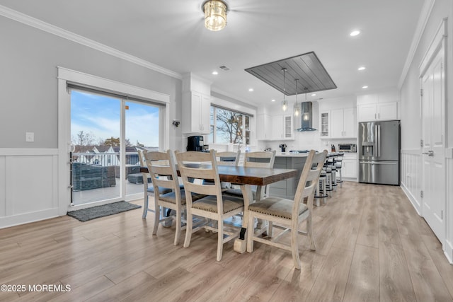 dining area featuring crown molding and light hardwood / wood-style floors