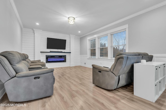 living room with ornamental molding and light hardwood / wood-style floors