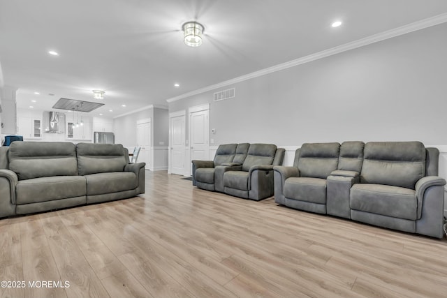 living room with ornamental molding and light hardwood / wood-style flooring