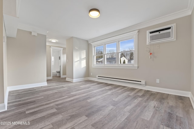 empty room with ornamental molding, light wood-type flooring, a wall mounted AC, and baseboard heating