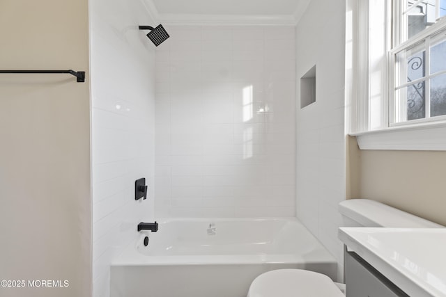 full bathroom featuring vanity, tiled shower / bath combo, ornamental molding, and toilet