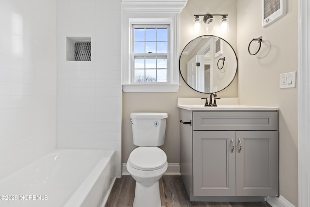 full bathroom featuring vanity, hardwood / wood-style flooring, tiled shower / bath combo, and toilet