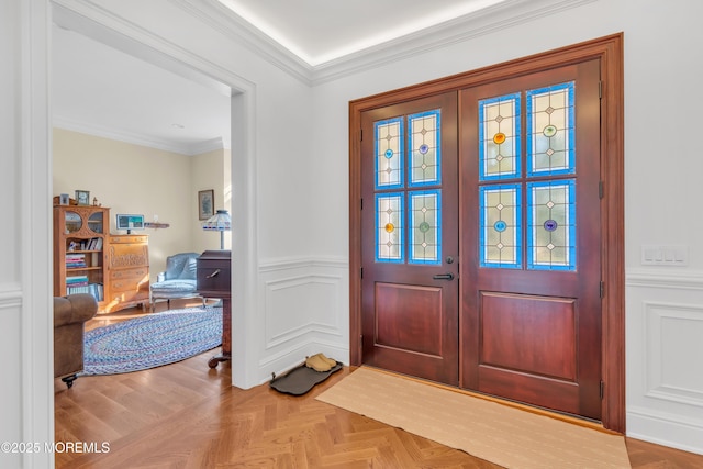 entryway with crown molding, french doors, and light parquet floors