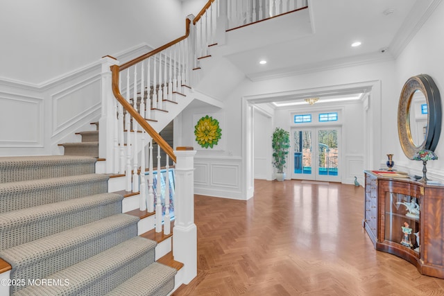 foyer entrance featuring ornamental molding, parquet floors, and french doors