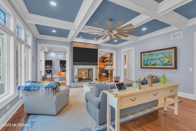 living room with beam ceiling, hardwood / wood-style flooring, coffered ceiling, and a multi sided fireplace