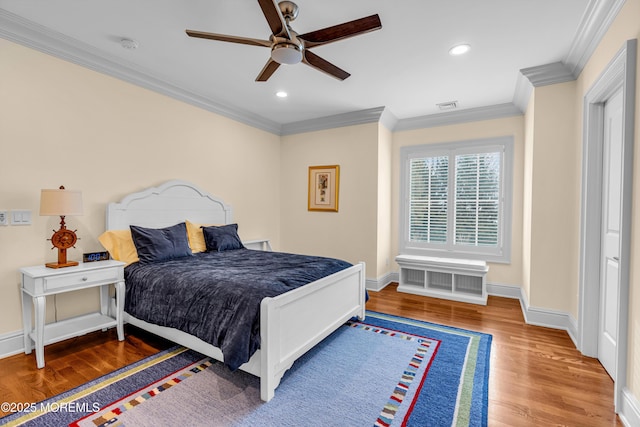 bedroom featuring crown molding, hardwood / wood-style flooring, and ceiling fan