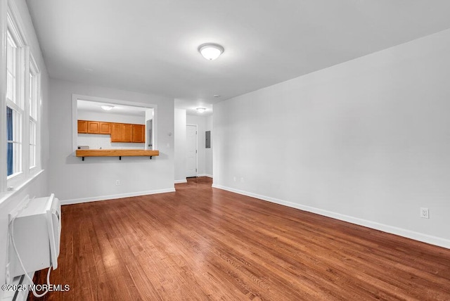 unfurnished living room with hardwood / wood-style floors and an AC wall unit