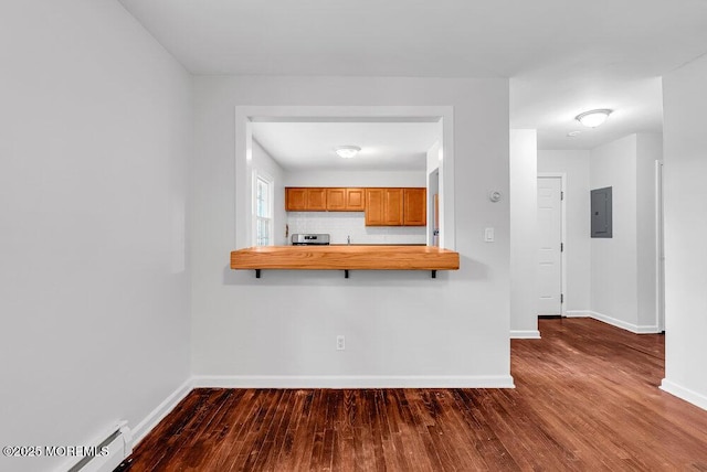 kitchen featuring stainless steel stove, dark hardwood / wood-style flooring, electric panel, baseboard heating, and kitchen peninsula