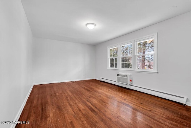 empty room with a baseboard radiator, a wall mounted AC, and hardwood / wood-style floors