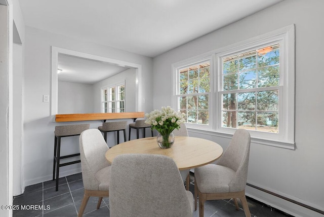 tiled dining area featuring a baseboard heating unit