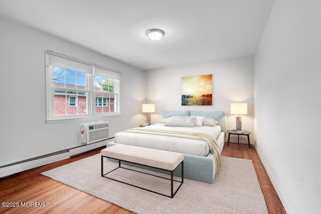 bedroom featuring wood-type flooring, a wall mounted air conditioner, and a baseboard radiator