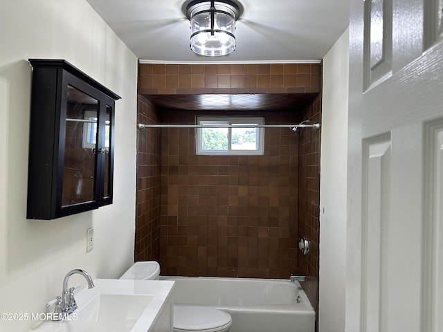 full bathroom featuring tiled shower / bath, toilet, and sink