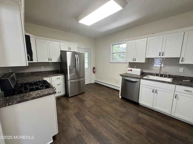 kitchen with stainless steel appliances, a baseboard heating unit, sink, and white cabinets