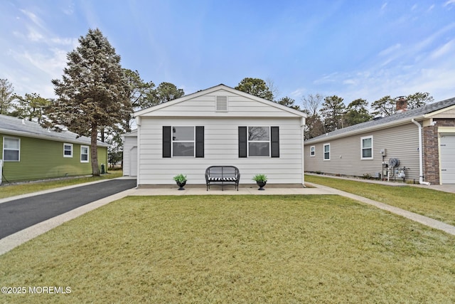 bungalow-style home featuring a garage and a front yard