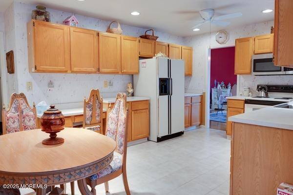 kitchen with ceiling fan, white appliances, and light brown cabinetry