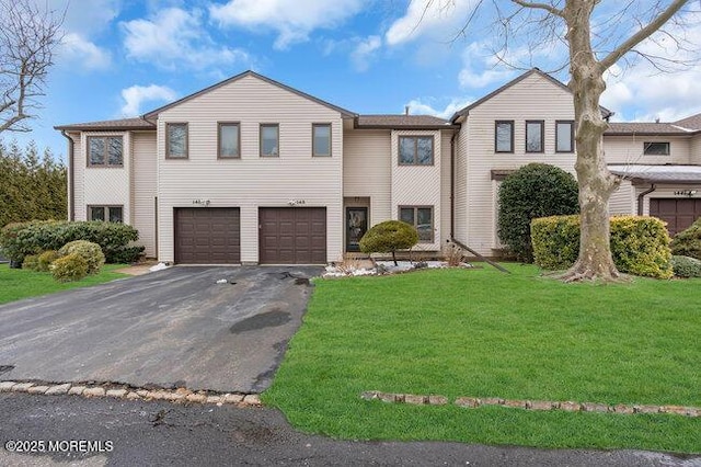 view of front of house with a garage, driveway, and a front lawn