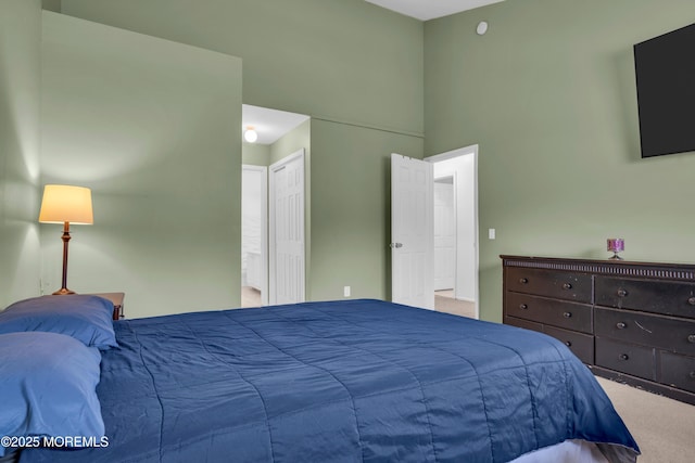 carpeted bedroom with a high ceiling