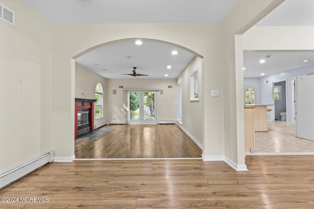 entryway with ceiling fan, light hardwood / wood-style floors, and a baseboard heating unit