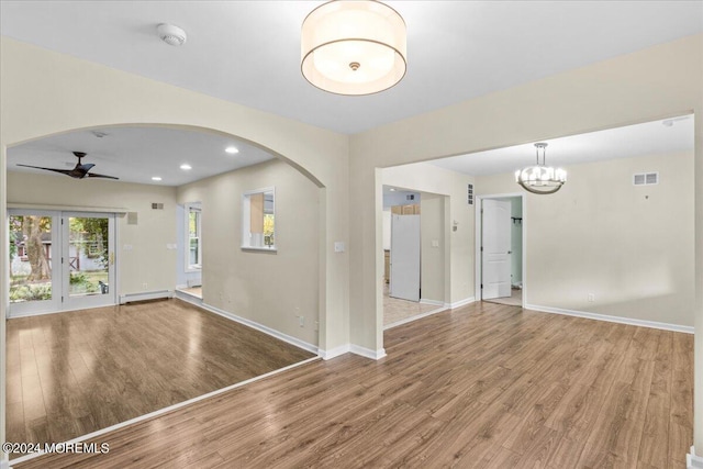 foyer with hardwood / wood-style flooring, a baseboard heating unit, and ceiling fan with notable chandelier