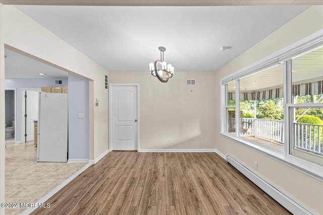 empty room with a baseboard radiator, light wood-type flooring, and a chandelier