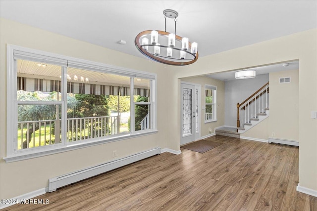 entryway with hardwood / wood-style flooring, a chandelier, and baseboard heating