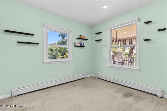 carpeted spare room with a baseboard heating unit