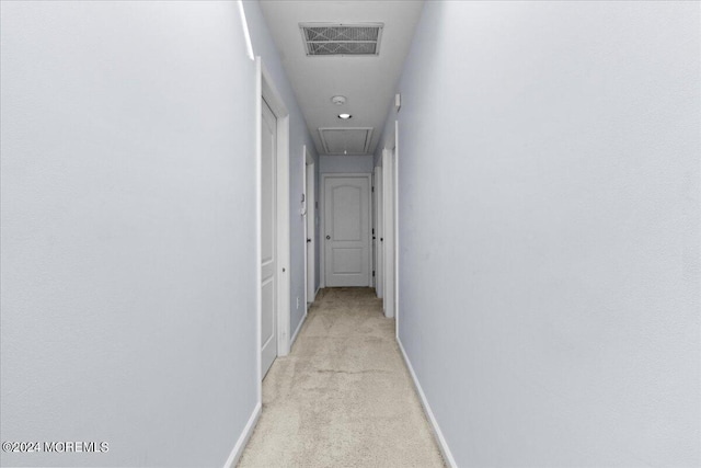 hallway featuring light colored carpet