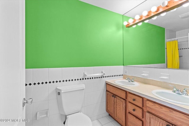 bathroom featuring vanity, toilet, a shower with shower curtain, and tile walls