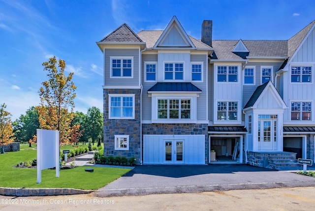 view of property featuring french doors and a front lawn