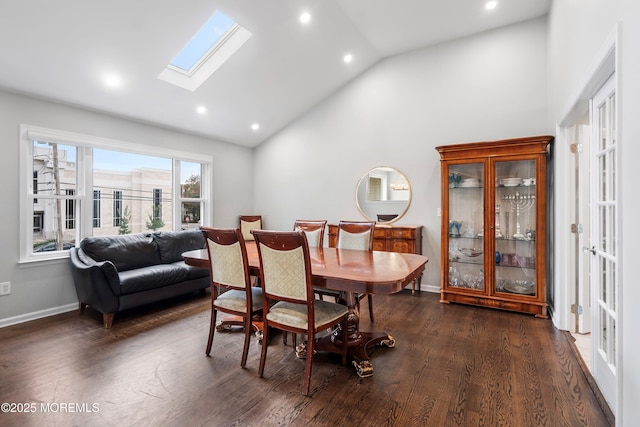 dining space featuring a skylight, high vaulted ceiling, and dark hardwood / wood-style floors