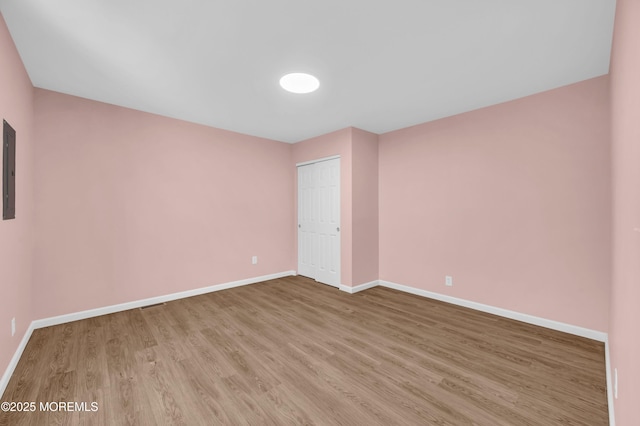 unfurnished room featuring electric panel and light wood-type flooring