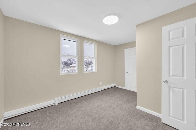 carpeted empty room featuring baseboard heating