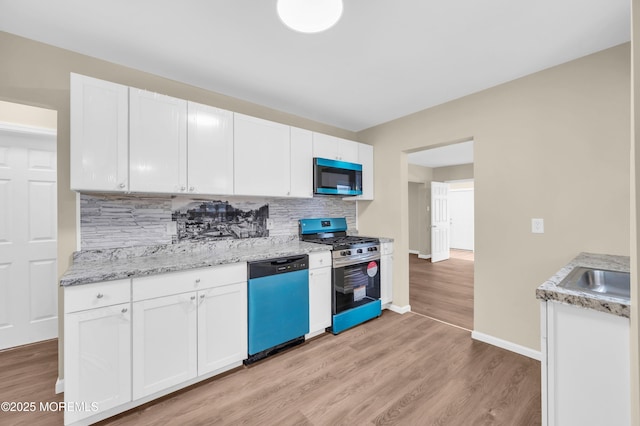 kitchen featuring backsplash, stainless steel appliances, sink, and white cabinets