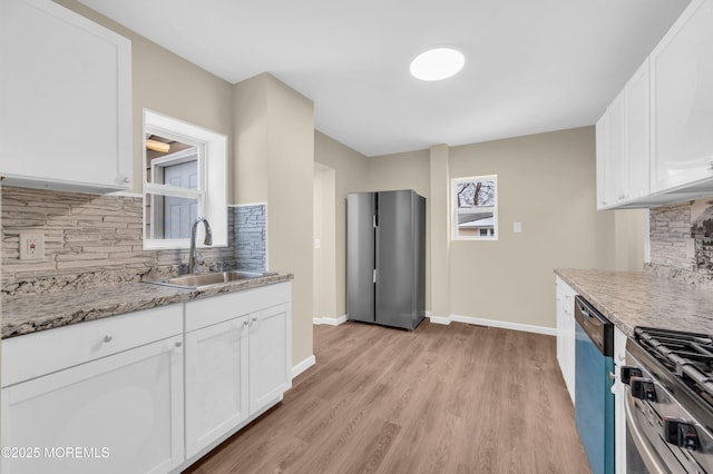 kitchen with sink, light wood-type flooring, stainless steel range, dishwasher, and white cabinets