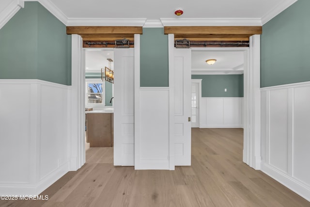 hall with ornamental molding and light hardwood / wood-style floors